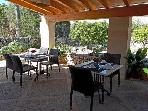 a patio with tables and chairs under a pergola at son capellot in Felanitx