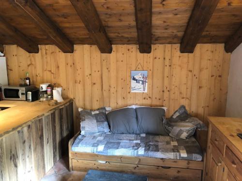 een bed in de hoek van een kamer met houten wanden bij Appartement Du Dou Des Ponts in Pralognan-la-Vanoise