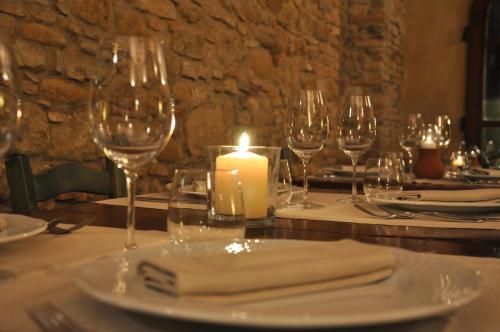 a table with wine glasses and a candle on it at Salvadonica in San Casciano in Val di Pesa