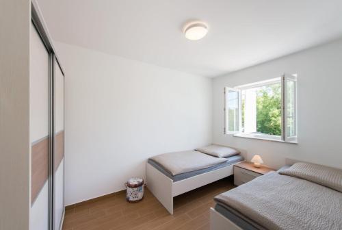 1 dormitorio con 2 camas y ventana en FEWO Villa Adria, en Barušić