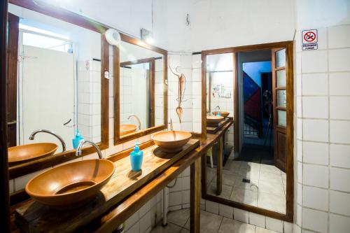 Baño con 4 lavabos y una fila de espejos en Rupestre Hostel en Córdoba