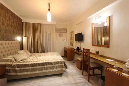a hotel room with two beds and a television at Hotel Mallas in Nea Kalikratia