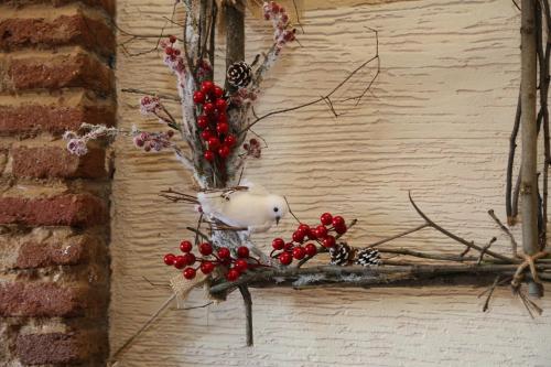 a bird sitting on a branch with berries on it at Atlant Hotel in Tbilisi City