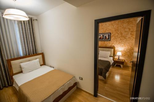 a bedroom with two beds and a mirror in a room at Hotel Flamingo in Korçë