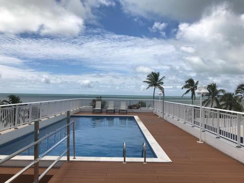 a swimming pool on the balcony of a resort with the ocean at Jardins do Atlântico Cabo Branco Beira-Mar in João Pessoa