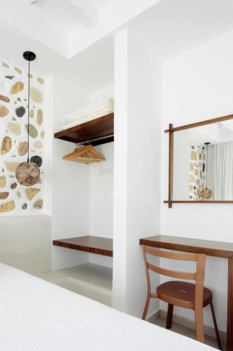 ein Schlafzimmer mit Schreibtisch, Tisch und Stuhl in der Unterkunft La Pierre in Limenaria