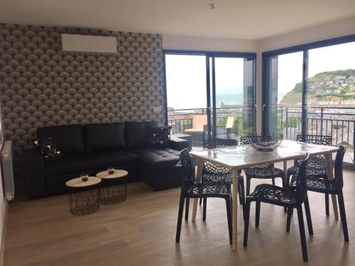 un salon avec une table et un canapé dans l'établissement Les Embruns Fecampois, à Fécamp