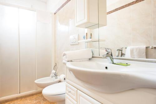 bagno bianco con lavandino e servizi igienici di Welcome Residence per famiglie a Rimini