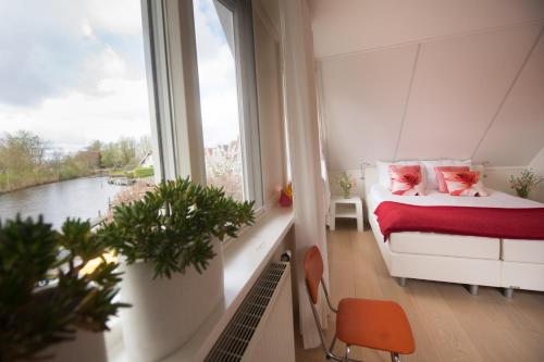 a bedroom with a bed and a large window at Villa Envie in Terherne