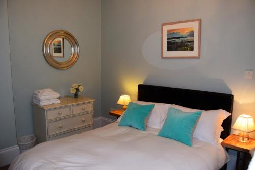 a bedroom with a white bed with blue pillows at Awel Mor 3 Luxury Apartment in Aberystwyth