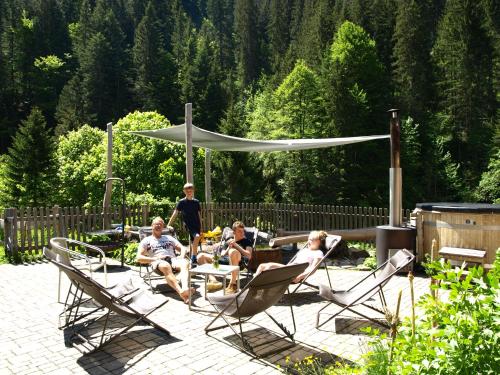 a group of people sitting in chairs on a patio at Vital Chalets in Schröcken
