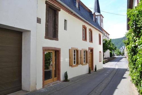 um edifício branco com janelas de madeira e uma rua em Ferienwohnungen Haus Dienhart em Piesport