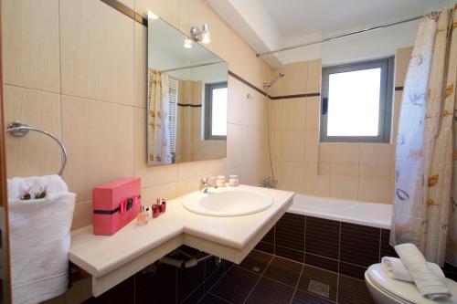 a bathroom with a sink and a bath tub at Gliving365 Capital in Argostoli