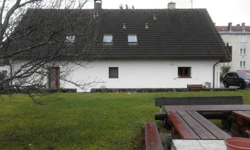 a white house with a black roof in a yard at Pod Smrcinou in Nová Pec