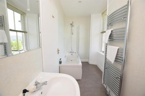 bagno bianco con lavandino e specchio di Kinnaird Country House a Pitlochry