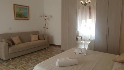 sala de estar con sofá y toallas en una cama en Sas Raicrinas, en Irgoli
