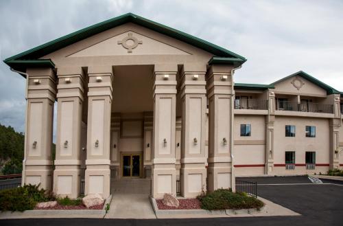 a large white building with a green roof at Baymont by Wyndham Keystone Near Mt. Rushmore in Keystone