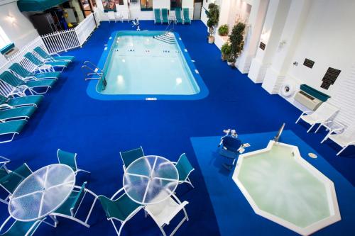 an indoor swimming pool with chairs and a blue floor at Baymont by Wyndham Keystone Near Mt. Rushmore in Keystone