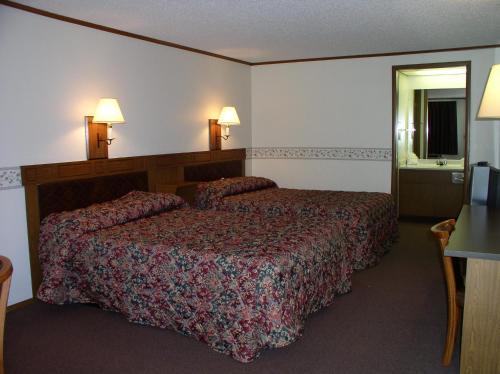 a hotel room with a bed and two lamps at Arbor Inn of Historic Marshall in Marshall