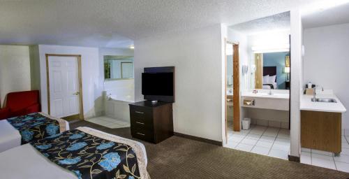 a bathroom with a bed and a tub and a television at Baymont by Wyndham Keystone Near Mt. Rushmore in Keystone