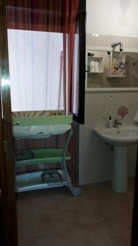 a bathroom with a sink and a toilet and a mirror at Casa Marina Lu Tuvaraggiu Casa vacanze in Sorso