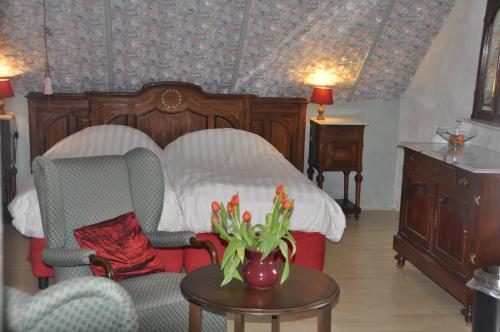 a bedroom with a bed and a table and chairs at De Hoge Peel in Heythuysen