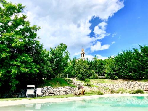 two chairs and a clock tower in the distance at Agriturismo La Perlara - Adults Only in Verona