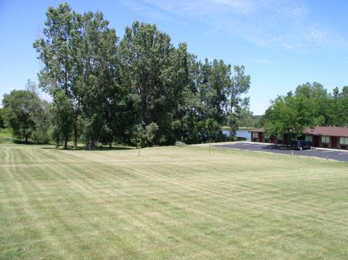 a large field of grass with trees and a building at Arbor Inn of Historic Marshall in Marshall