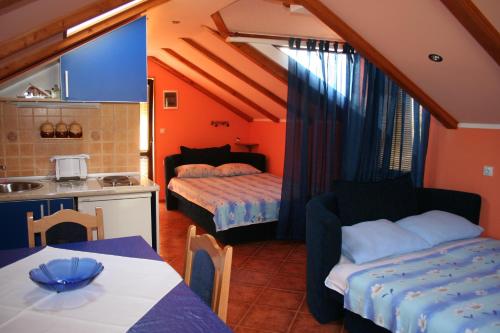 a small room with a kitchen and a bed and a table at Apartments Penovic in Kotor