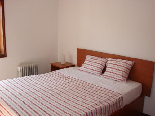 een slaapkamer met een bed met 2 kussens bij Apartamento S. João da Foz in Porto