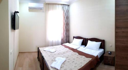 um quarto com uma cama com duas almofadas e uma janela em Apartament Old Avlabar em Tbilisi