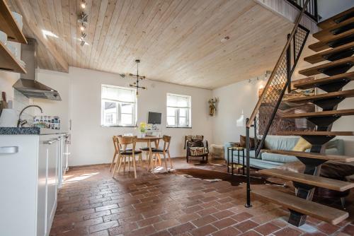 eine Küche und ein Wohnzimmer mit einer Treppe und einem Tisch in der Unterkunft Apan & Klyset in Simrishamn