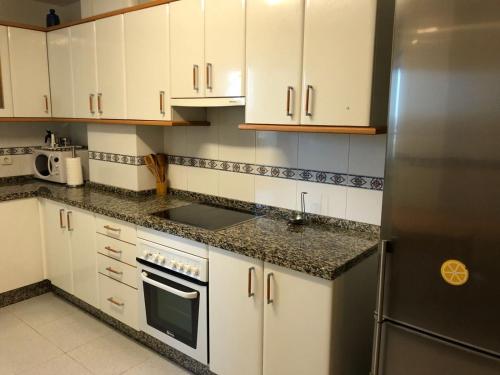 リバデオにあるEl piso de Carlosのキッチン(白いキャビネット、ステンレス製の冷蔵庫付)