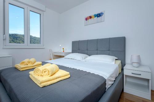 una camera da letto con un grande letto con asciugamani di Citta Vecchia Apartment modern and cosy apartment with magnificent harbour view a Stari Grad (Cittavecchia)