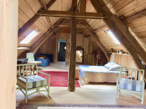 um quarto no sótão com um quarto e uma cama em Chantier d'art Contemporain La Serverie em Saint-Rémy