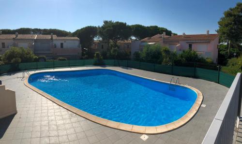 une grande piscine bleue dans une cour dans l'établissement Appartement cap d'agde, au Cap d'Agde