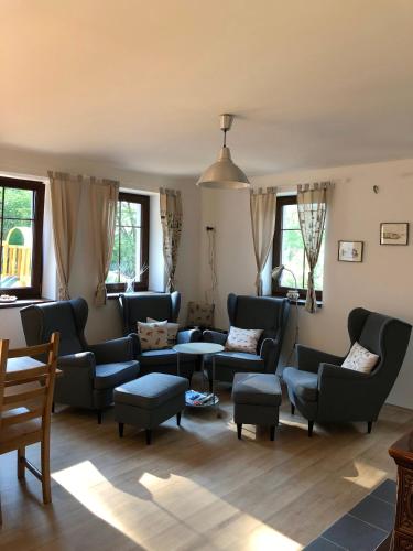 a living room with couches and tables and windows at Apartmány Sportrelax in Albrechtice v Jizerských horách