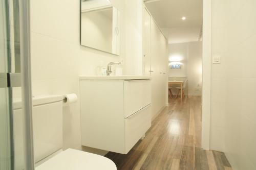 Baño blanco con lavabo y aseo en Zuhaizti Apartment, en San Sebastián