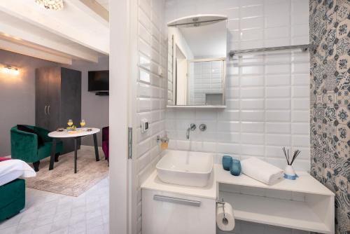 Baño blanco con lavabo y mesa en Kampanel 10 en Hvar