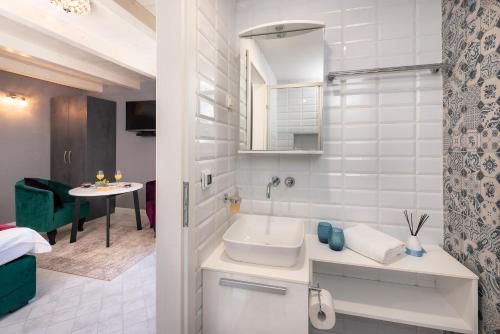 ein weißes Badezimmer mit einem Waschbecken und einem Tisch in der Unterkunft Kampanel 10 in Hvar