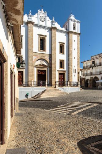 a large white building with a clock tower at Heaven Inn Suites & Terrace in Évora