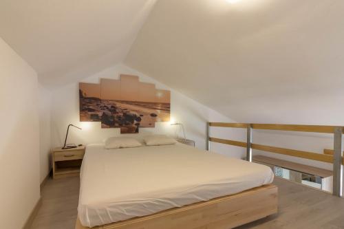 a bedroom with a white bed and a picture on the wall at AirCon Los Cristianos, Quiet zone, Chipeque in Arona