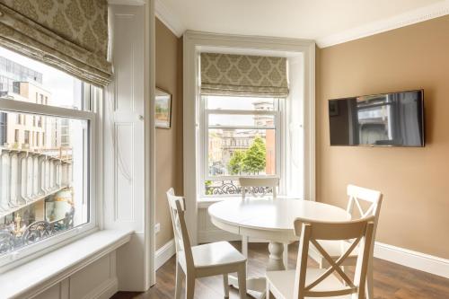 a dining room with a table and chairs and a window at Molloy's Apartments in Dublin