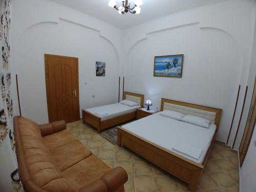 sala de estar con 2 camas y sofá en Guest House Urat, en Gjirokastra