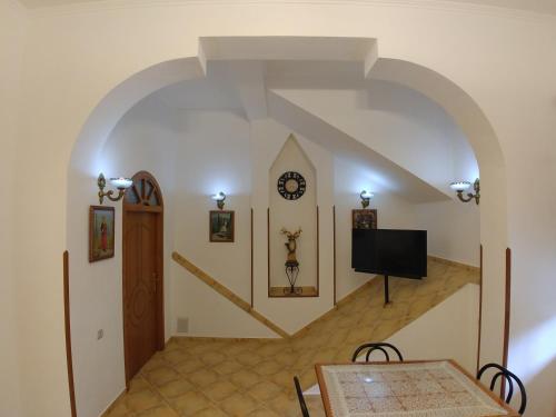 a hallway with a staircase with a clock on the wall at Guest House Urat in Gjirokastër