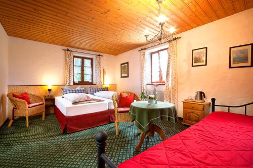 1 dormitorio con 2 camas, mesa y sillas en Landhotel Huberhof, en Schwangau