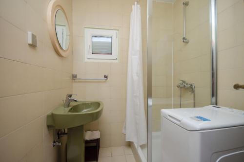 a bathroom with a sink and a toilet and a shower at Apartment RUZA in Lopar