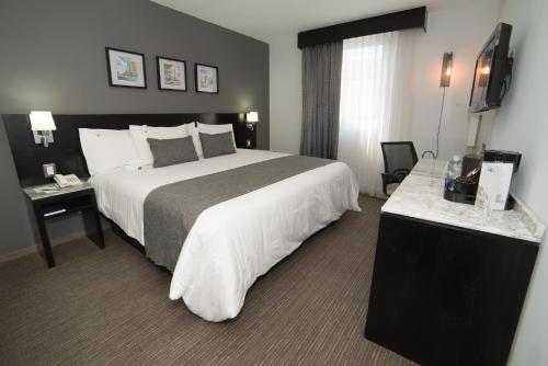 a hotel room with a large bed and two tables at LaiLa Hotel CDMX Reforma in Mexico City