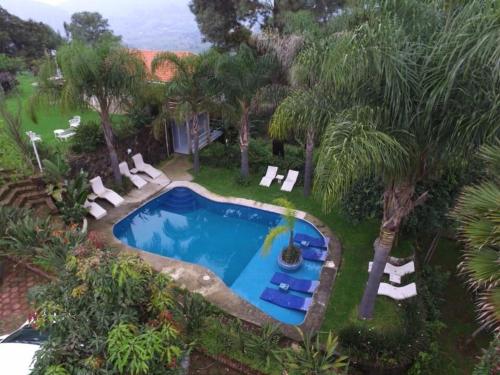 una vista aérea de una piscina con tumbonas y árboles en Hotel El Mirador y Jardin, en Tlayacapan