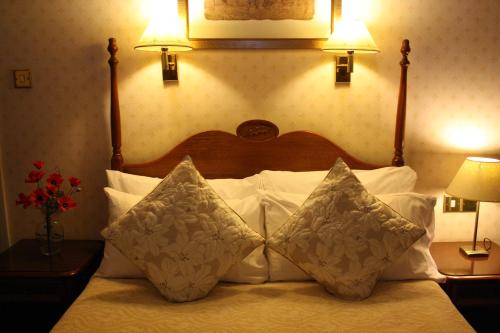 a bedroom with a bed with white pillows and two lamps at 17 Wilmington Square in Eastbourne